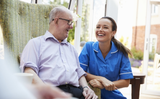 Caregiver laughing with a patient